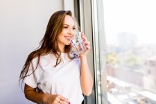 woman-holding-glass-water-while-looking-out-window-back-silhouette-woman.jpg