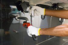 plumber-fixing-white-sink-pipe-with-adjustable-wrench.jpg