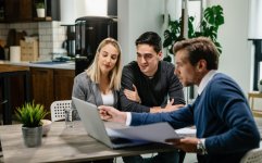 young-couple-real-estate-agent-using-laptop-while-going-through-housing-plan-meeting.jpg